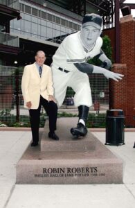 Hall of Fame pitcher Robin Roberts poses next to his statue